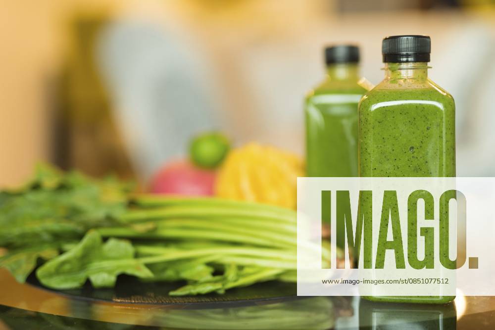 Porträt zweier Flaschen gefüllt mit einer gesunden grünen Smoothie Mischung aus Obst und Gemüse als Konzept für einen gesunden Lebensstil Portrait of two bottles filled with healthy green smoothie mixture of fruits and vegetables as healthy lifestyle concept
