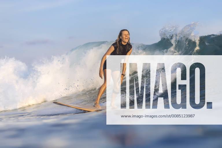Front view shot of single woman riding wave in sea while surfing, Kuta Lombok Indonesia TRKO020214 model released Symbolfoto