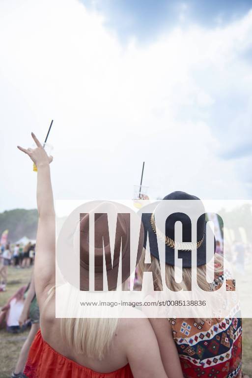 Friends cheering and holding plastic cups during music festival model released Symbolfoto ABIF00600