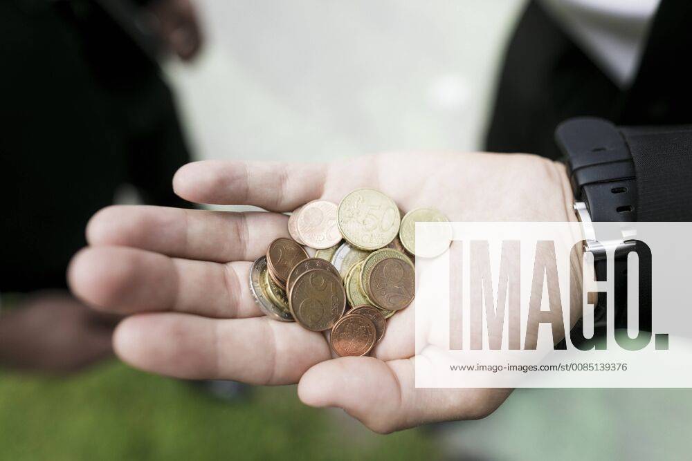 Euro coins in the hand of a businessman model released Symbolfoto KMKF00382