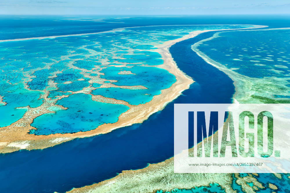 Luftaufnahme der lebhaften Korallenformationen des Great Barrier Reef. Aerial view of the Great Barrier Reef, Australia, showcasing its vibrant coral formations and clear turquoise waters, a vital ecosystem facing climate change threats. (License=RF)