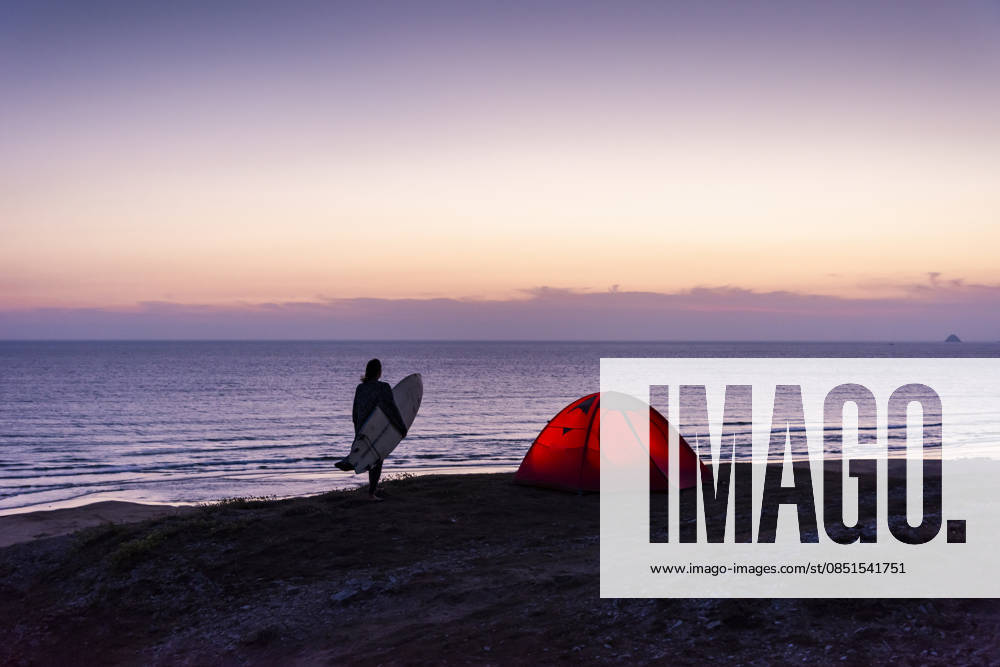 Silhouette with surfboard and tent by the sea at sunset model released, Symbolfoto, UUF36537