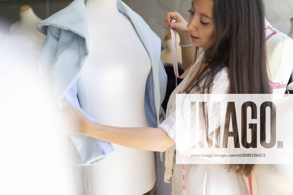 Young fashion designer fitting clothes on dressmaker s model model released Symbolfoto property released AFVF00765