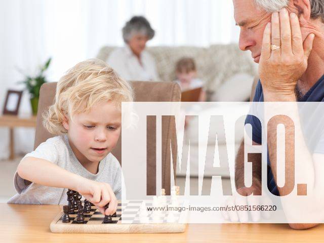 Young boy playing chess with his grandfather Young boy playing chess with his grandfather at home, model released, Cape Town, South Africa, 31.10.2010, 50670.jpg, board, chess, couch, face, family, fun, game, happy, home, house, indoor, innocent, joy, little, modern, play, retired, retirement, room, sitting, small, sofa, table, together, white 60s, Mature Adult, Man, Male, Caucasian, 50s, Woman, Female, Child, Girl, Boy, Caucasian Appearance, 60-64 Years, Senior Men, 55-59 Years, Mature Women, 4-5 Years, Girls, 6-7 Years, Boys
