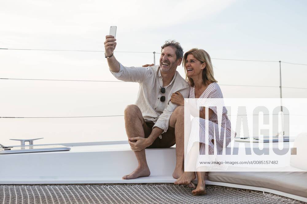 Happy couple on a sailing trip taking selfies model released Symbolfoto property released EBSF02632
