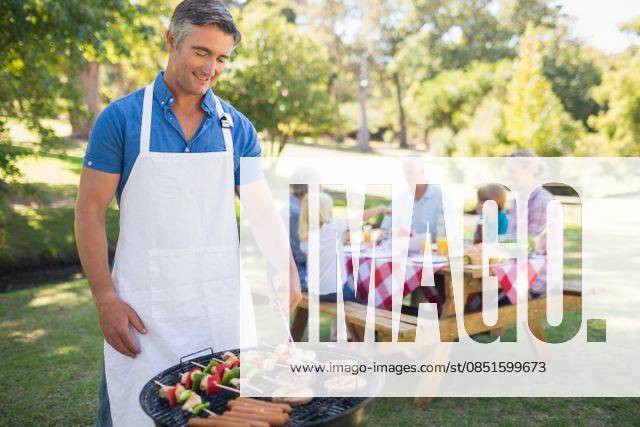 Happy man doing barbecue for his family Happy man doing barbecue for his family in a sunny day, model released, Cape Town, South Africa, 24.03.2015, 511818.jpg, park, countryside, nature, sunny, sunshine, summer, spring, lifestyle, leisure, fair hair, blonde, light hair, short hair, relaxing, content, happy, smiling, cheerful, love, affection, family, together, cute, childhood, family with two children, two parents, mother, father, daughter, son, grandparent, multi-generation family, recreational pursuit, weekend activities, barbecue, al fresco, lunch, meal, picnic table Child, Boy, Male, Caucasian, 40s, Mature Adult, Man, 60s, Senior, Elderly, 70s, Woman, Female, 30s, Mid Adult, Girl, 10-11 Years, Boys, Caucasian Ethnicity, 40-44 Years,