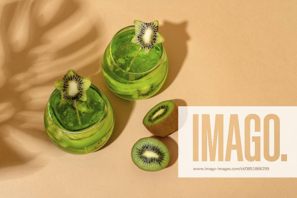 Tropische alkoholische Eiscocktails mit Kiwi, die im Sommersonnenlicht serviert werden. Trendiger Stil mit Schatten Tropical summer ice alcoholic cocktails with kiwi served under the summer sun light. Trendy style with shadows