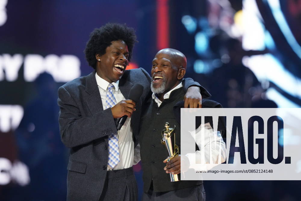 Daniel Caesar, left, accepts the award for Contemporary R&B Recording of the Year alongside his father Norwill Simmonds at the 2026 Juno Awards in Hamilton, on Sunday, March 29, 2026. Hamilton CANADA - ZUMAc35_ 20260329_zaf_c35_230
