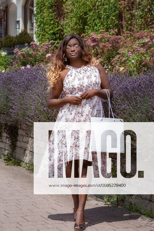 Dark-skinned plus size model with wide summer dress and elegant tote bag Dark skinned plus size model with wide summer dress and elegant tote bag 1098400153