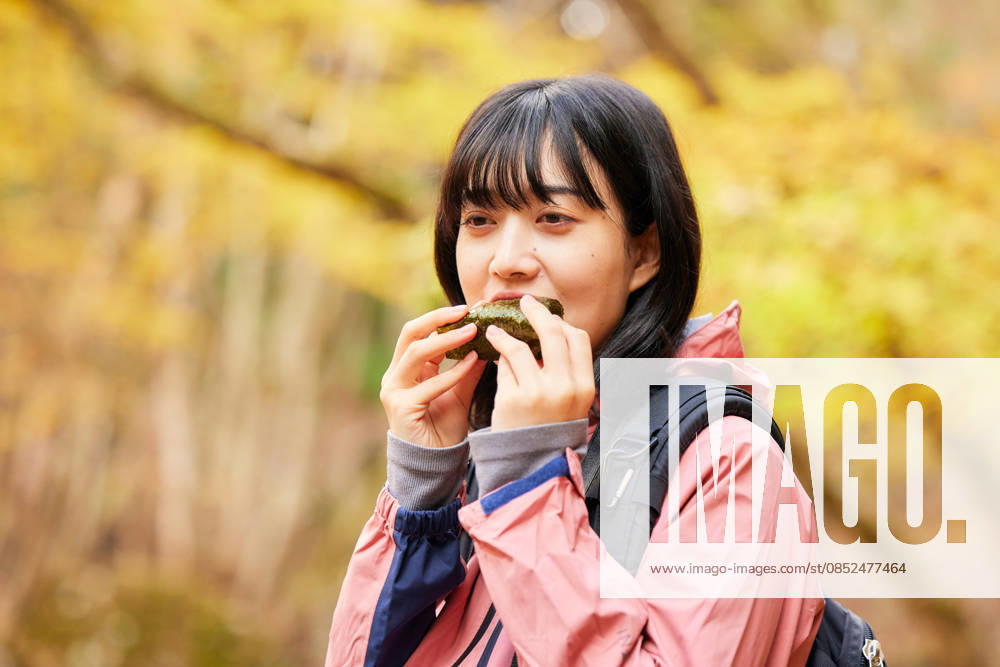 IMAGO Creative, Food, Japan, Onigiri Young Japanese woman refueling with a rice ball on an autumn hike AFLO316841519 316841519 ,model released, Symbolfoto