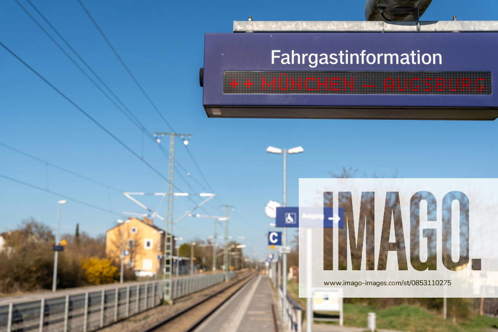 PHOTOMONTAGE, digital passenger information display at the train station showing Munich Augsburg. The image depicts a major commuter route in Bavaria and symbolizes frequent train service as well as potential disruptions in regional rail traffic.