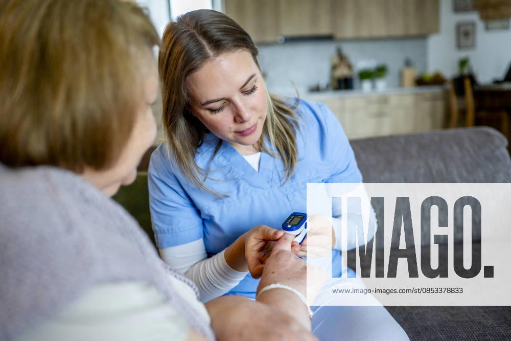 Diabetologist nurse testing blood sample on blood sugar meter. Diabetologist nurse testing blood sample on blood sugar meter, elderly woman diagnosed with diabetes. model released