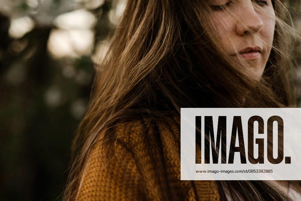 Close up of a woman with long brown hair with her eyes closed outdoors Calgary, Alberta, Canada CR_AMST26041009-1892963-01 ,model released, Symbolfoto ,property released