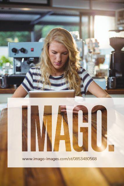 Woman sitting in a cafe using digital tablet Thoughtful woman sitting in a cafe using digital tablet, model released, , property released, Cape Town, South Africa, 30.05.2016, 797480.jpg, table, cafe, coffee shop, cafeteria, restaurant, hotel, casual clothing, sitting, holding, serious, thoughtful, web, internet, touching, reading, scrolling, digital tablet, tablet computer, tablet pc, touchscreen, wireless technology, communication, connection, lifestyle, leisure, pretty, attractive Indoors,Day