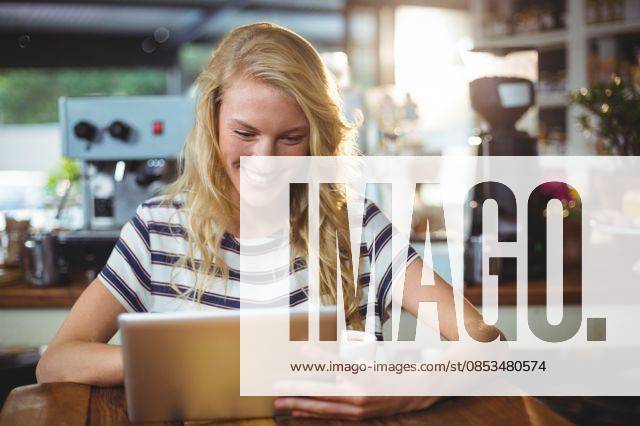 Woman sitting in a cafe using digital tablet Smiling woman sitting in a cafe using digital tablet, model released, , property released, Cape Town, South Africa, 30.05.2016, 797481.jpg, table, cafe, coffee shop, cafeteria, restaurant, hotel, casual clothing, sitting, holding, smiling, cheerful, web, internet, touching, reading, scrolling, digital tablet, tablet computer, tablet pc, touchscreen, wireless technology, communication, connection, happy, lifestyle, leisure, pretty, attractive Indoors,Day