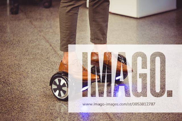 Business executive standing on hoverboard Business executive standing on hoverboard in office, model released, , property released, Cork, Ireland, 19.03.2016, 874600.jpg, office, workplace, executive, standing, floor, marble, balancing, board, hoverboard, self-balancing, illuminated, electric, balance, technology, wheel, modern, futuristic, two-wheeled, graphic designer, artist, profession, professional, occupation, job, electronic, creative, creativity, skill