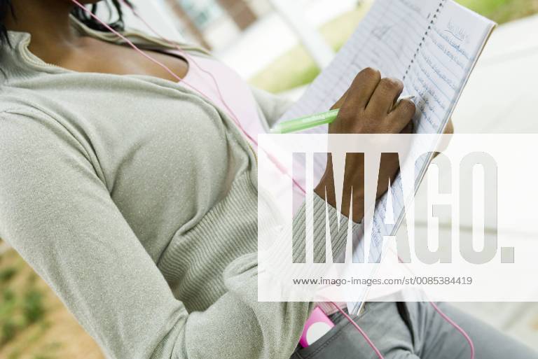 Student writing in notebook, cropped