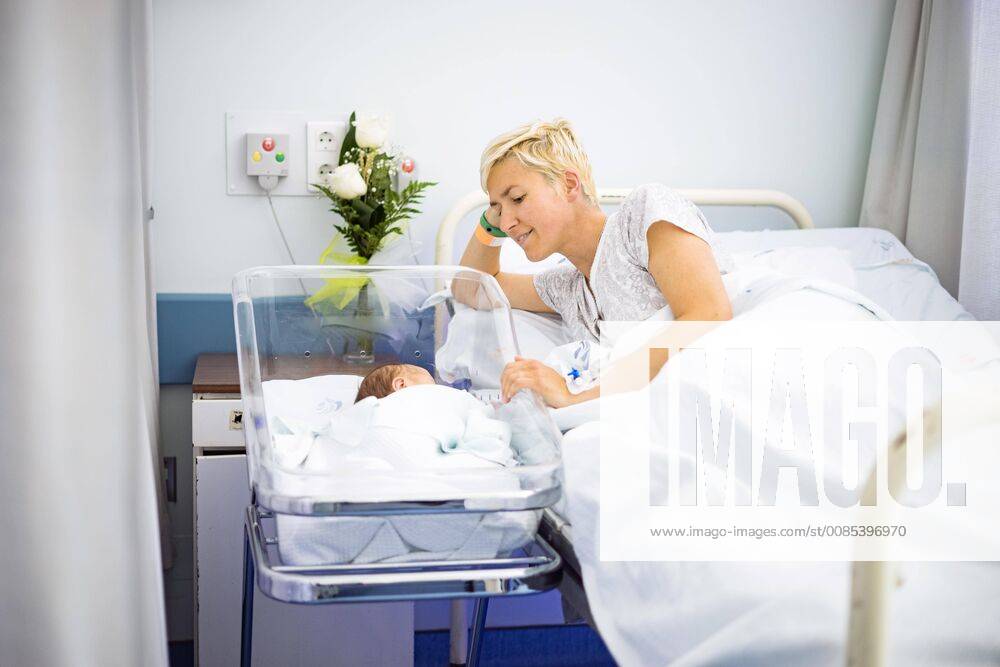 Mother lovingly looking at her newborn baby still in the hospital