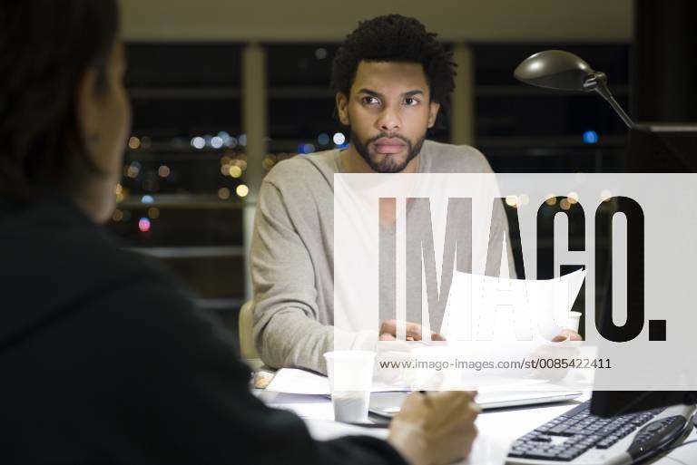 Colleagues working on project together in office at night