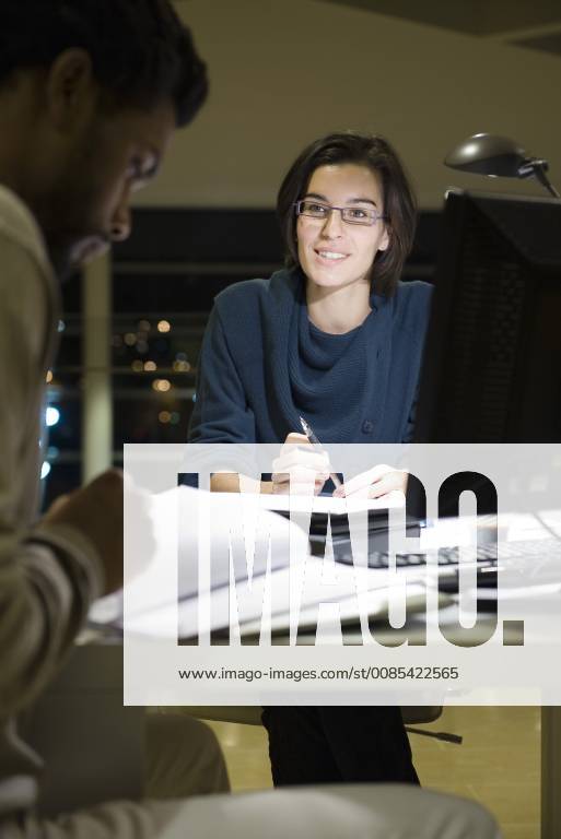 Colleagues working on project together in office at night