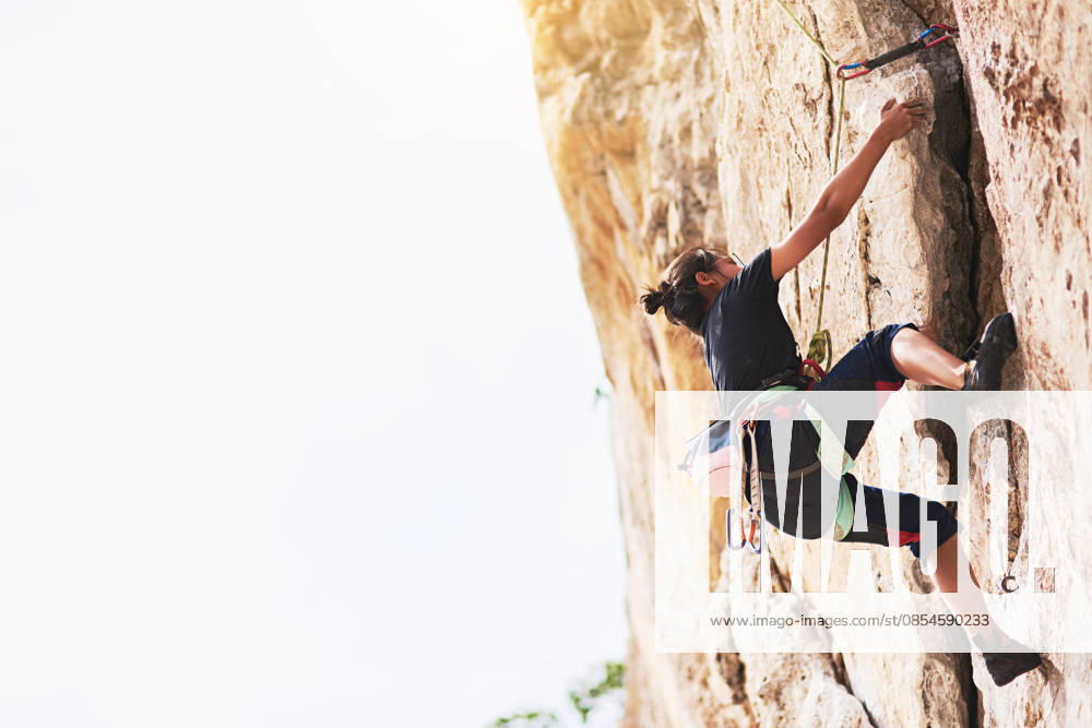 Dont stop until you reach the top. a young rock climber scaling a cliff face (License=RF) ,model released, Symbolfoto