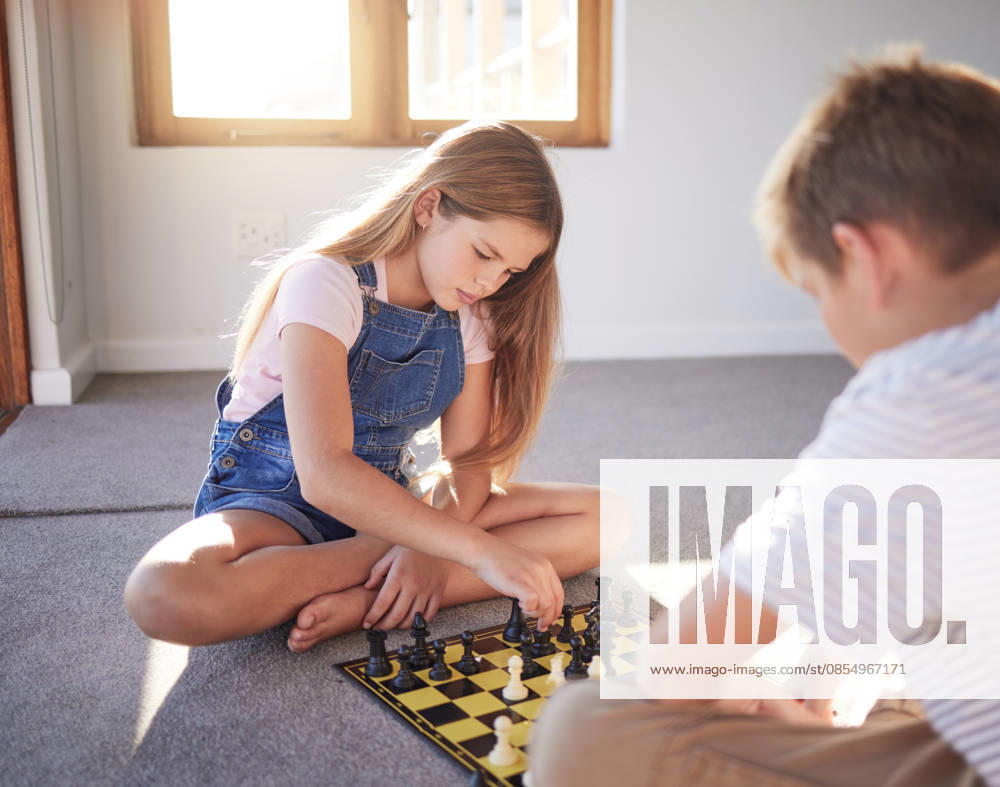 Children, chess and boardgame with a girl and boy playing on the floor of their home together. Brain, thinking and strategy with a brother and sister bondng or learning to play a game on a chessboard. (License=RF) ,model released, Symbolfoto