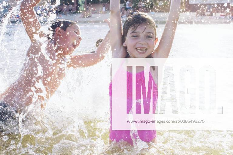 Siblings playing in water