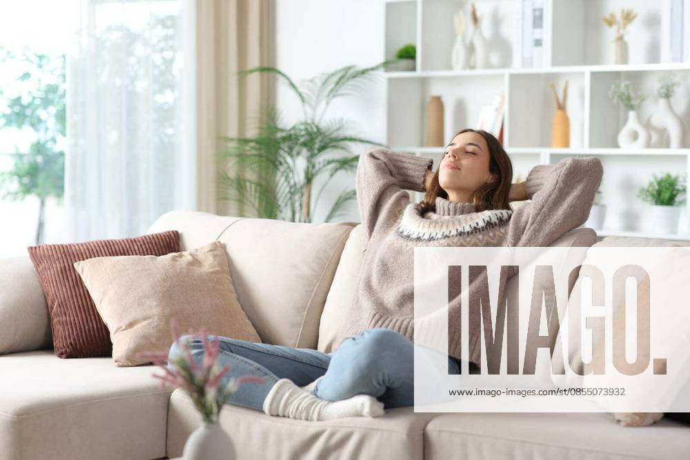 Relaxed woman in winter enjoying free time sitting on a sofa at home model released Symbolfoto
