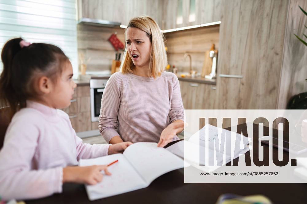 Die Mutter hilft ihrer Tochter bei den Hausaufgaben, während sie am Küchentisch sitzt und frustriert ist Frustrated mother guides her daughter through assignments at home. (License=RF) ,model released, Symbolfoto