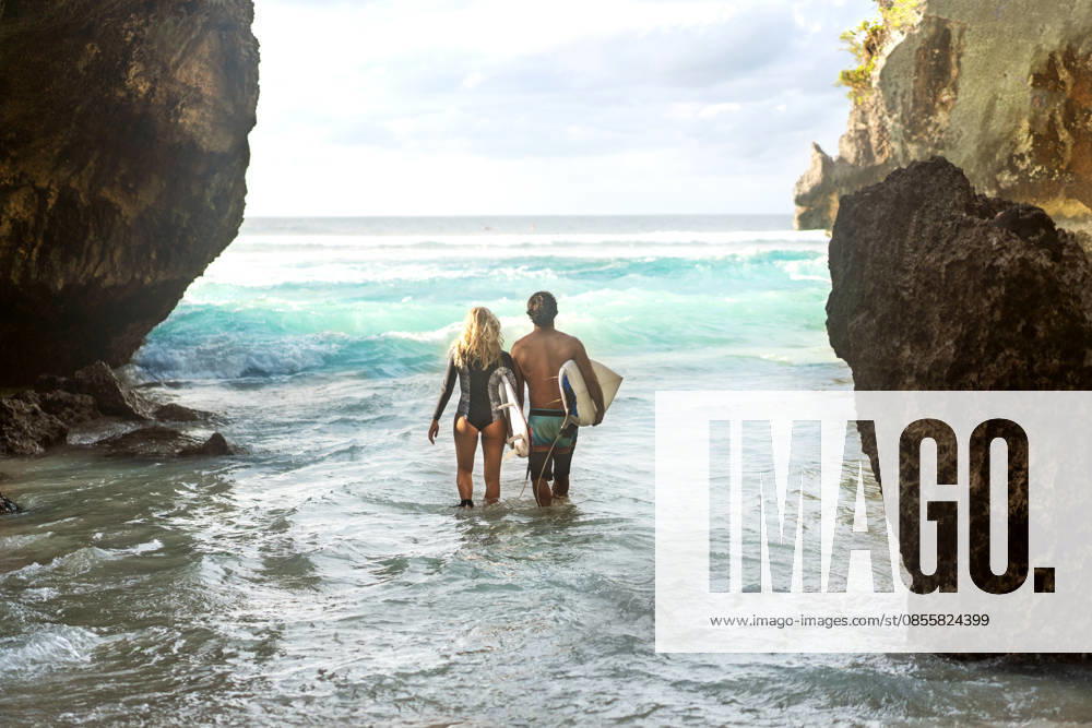 A couple in Bali walks into the ocean with surfboards. Kuta Selatan, Bali, Indonesia CR_NAOS260410-1992010-01 ,model released, Symbolfoto