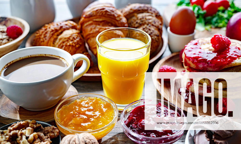 Frühstück serviert mit Kaffee, Orangensaft, Pfannkuchen, Croissant Breakfast served with coffee, orange juice, pancakes, croissants, cereals and eggs. (License=RF)