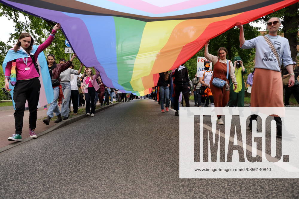 People walk with a rainbow flag in the Pappelallee during a demonstration for Christopher Street Day in Potsdam, May 9, 2026 CSD in Potsdam