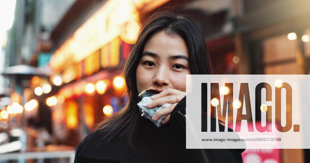 IMAGO Creative, Food, Japan, Onigiri Travel, eating and Asian woman with onigiri in the city on exploring vacation, adventure or holiday.Portrait, food and young female person enjoying a Japanese snack or meal in town on weekend trip (License=RF) ,model released, Symbolfoto