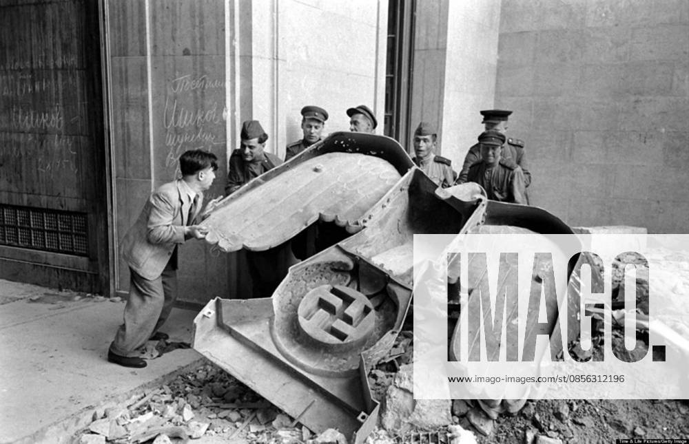 Photograph of Russian soldiers and a civilian struggle to move a large bronze Nazi Party eagle Photograph of Russian soldiers and a civilian struggle to move a large bronze Nazi Party eagle that once loomed over a doorway of the Reich Chancellery, Berlin. Dated 1945 Editorial use only. All other uses to be cleared with the copyright owner (World History Archive), in advance., WHA_068_0428.jpg, Russian soldiers; civilian; struggle; move; large bronze; Nazi Party eagle; Reich Chancellery; Berlin; 1945; World War II; historical; monument; war; conflict; victory; teamwork; cooperation; effort; strength; power; symbol; history; military; occupation; Europe; Germany; Soviet Union; allies; liberation; resistance; iconic.