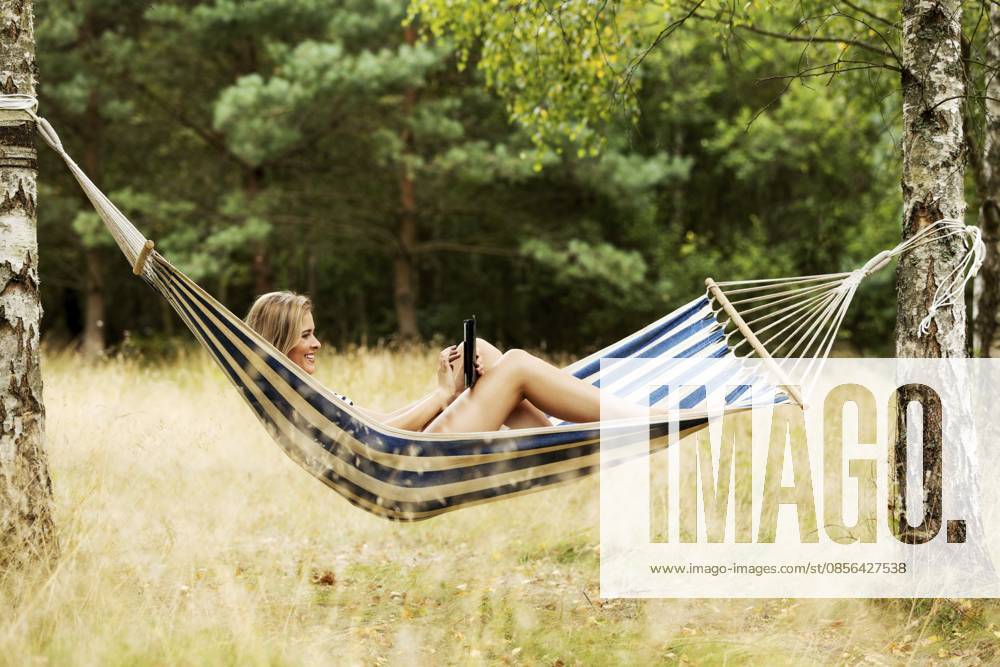 Junge Frau mit Tablet auf der Hängematte Young woman with tablet on the hammock