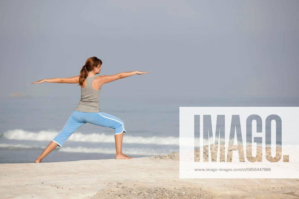 Beautiful young woman with arms open, relaxing on the beach model released Symbolfoto