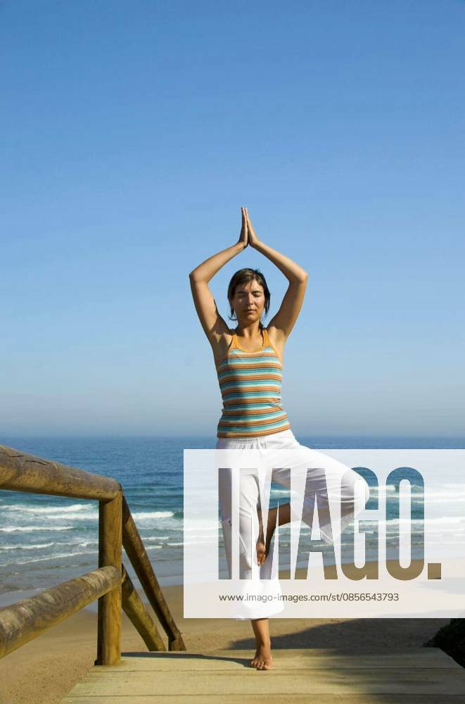 Beautiful young woman doing yoga on the beach model released Symbolfoto