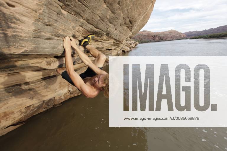 Andy Lewis bouldering over the Colorado river at Gold Bar just outside Moab, Utah, Moab Utah United States