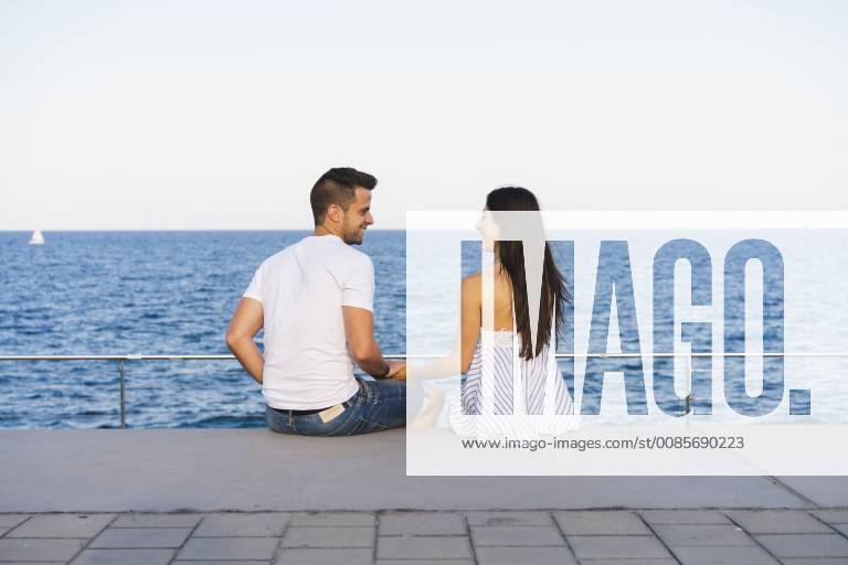 Happy young couple standing by the sea model released Symbolfoto AFVF01167