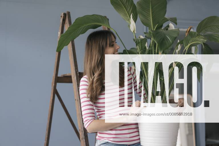 Woman holding potted plant in her bew home model released Symbolfoto property released JOSF02364