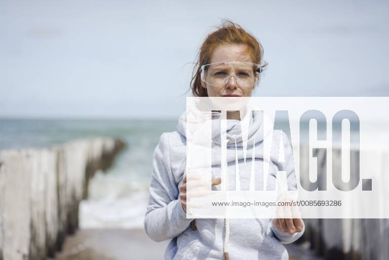 IMAGO Creative: Corporate: Klimaschutz, Digitalisierung und Urbanisierung IMAGO Creative: Klimawandel - Zukunft und Innovation Scientist with safety glasses taking water samples at the beach model released Symbolfoto KNSF04300
