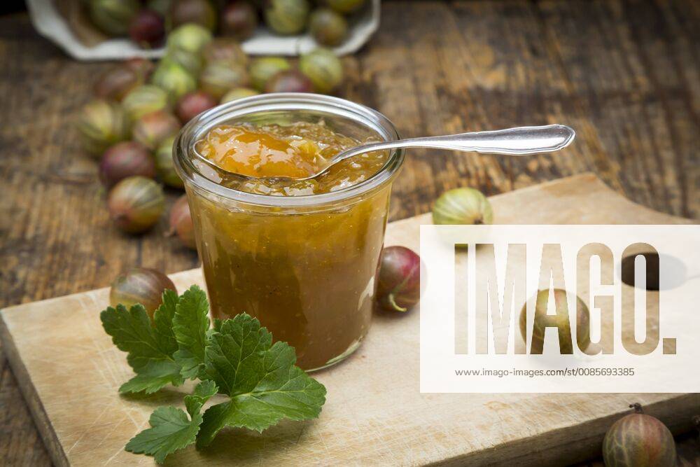 Jar of gooseberry jam and gooseberries on wooden board LVF06268