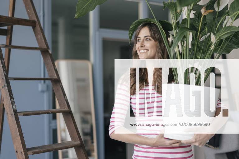 Woman holding potted plant in her bew home model released Symbolfoto property released JOSF02365