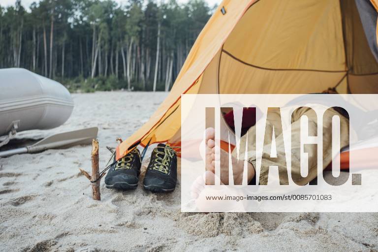 Man lying in tent on beach model released Symbolfoto VPIF00424