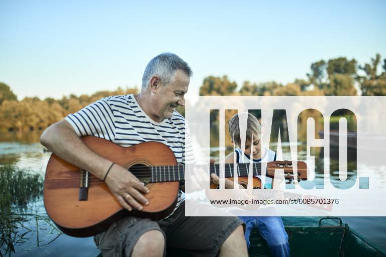 Grandfather teaching grandson playing guitar model released Symbolfoto ZEDF01497
