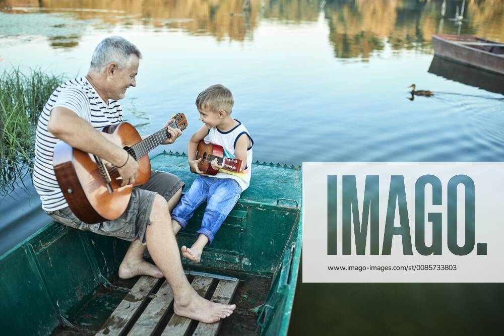 Grandfather teaching grandson playing guitar model released Symbolfoto ZEDF01499