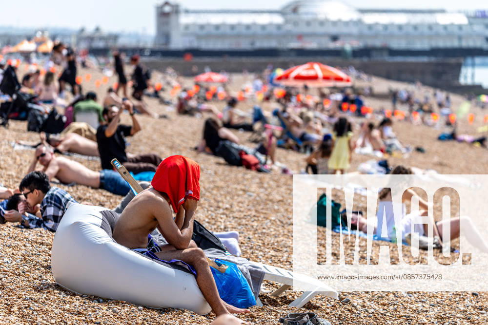 London, UK. Sun seekers enjoy the hot sun on Brighton Beach, East Sussex today as weather forecasters issue Amber weather warnings for high temperatures this Bank Holiday weekend. The Met Office has predicted a mini heatwave for the May Bank Holiday and school half term with temperatures expected to hit over 32c in London and the South East this week, possibly making it the hottest May on record. Brighton UK - ZUMAl94_ 20260523_zaf_l94_010