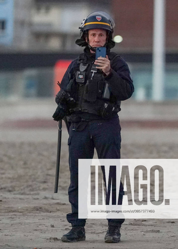 Dunkirk, France. A police officer filming on a mobile phone as migrants attempts to board an inflatable boat at the beach at Dunkirk, to cross the English Channel. More than 200,000 migrants have crossed the Channel in small boats since 2018. Dunkirk France - ZUMAl94_ 20260523_zaf_l94_034