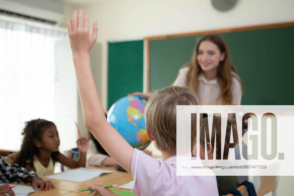 Die Lehrerin betreut die Kinder in einer multiethnischen Klasse The teacher is providing guidance to children in a multiethnic classroom during a creative activity in the elementary school (License=RF) ,model released, Symbolfoto
