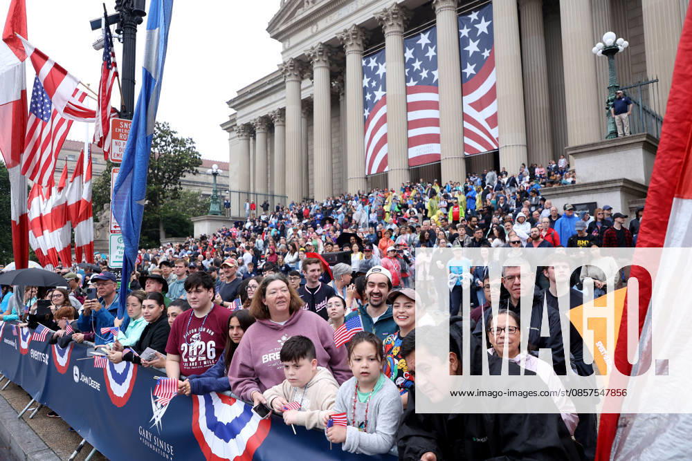 Attendees holding American flags watch the National Memorial Day Parade in Washington, DC, USA, on May 25, 2026. The parade has been held annually since 2005, marking its 21st anniversary. Washington USA - ZUMAs337 20260525_znp_s337_024